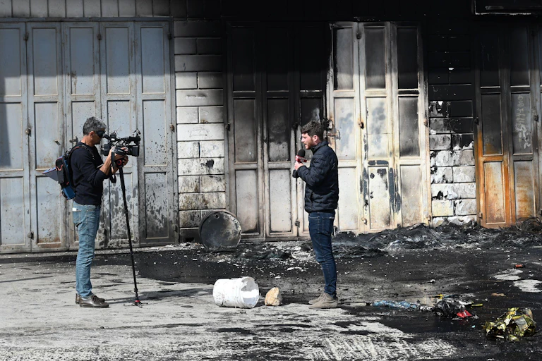 A man with a camera and a man with a microphone, set up for an interview.