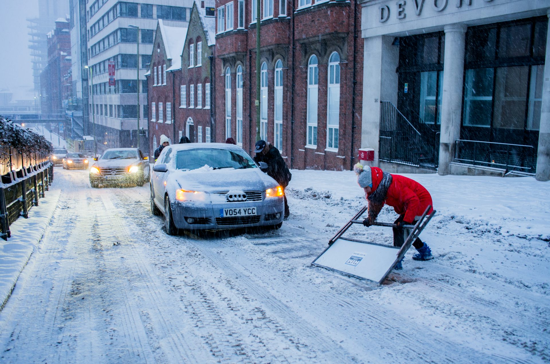 Cars and people in the snow.