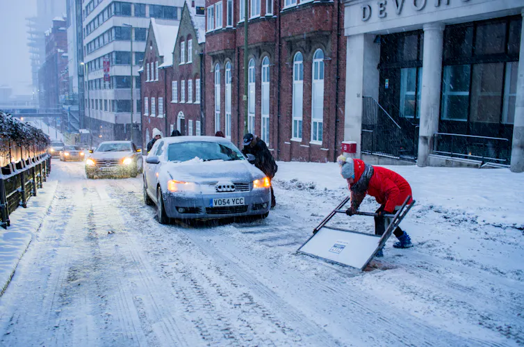 Cars and people in the snow.