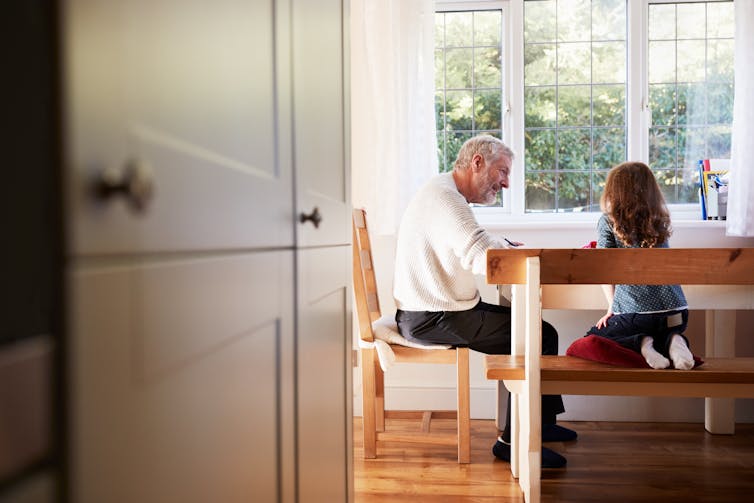 A grandfather and grandchild at a table.