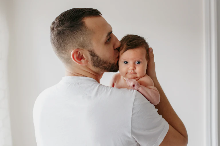 Young man kissing baby on head