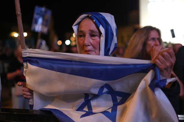 An Israeli woman holds up a national flag.