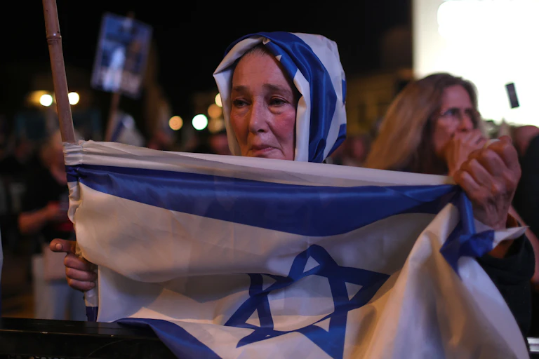 An Israeli woman holds up a national flag.