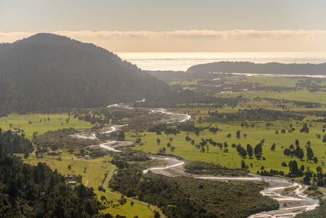 coastal land and river with sea in background