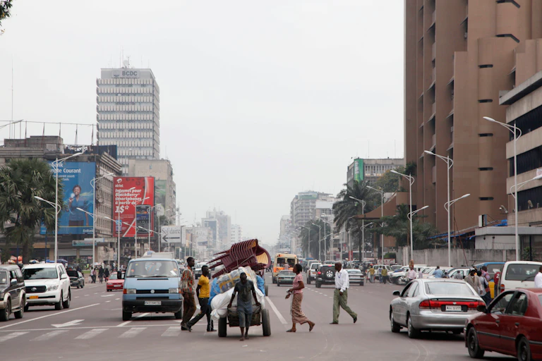 A look down a busy city street filled with cars and people.