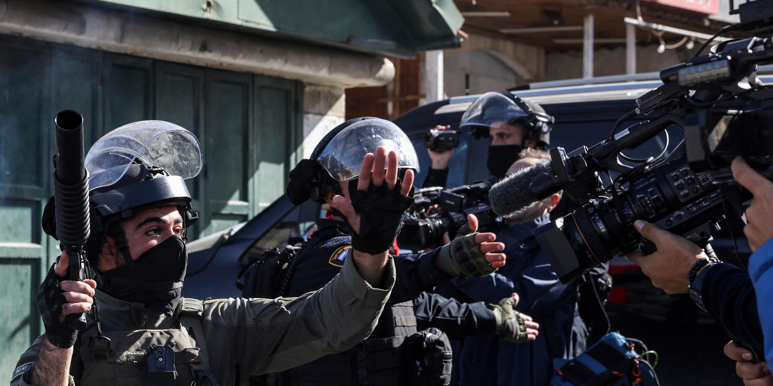 Des militaires armés et en uniforme face à des journalistes qui les filment