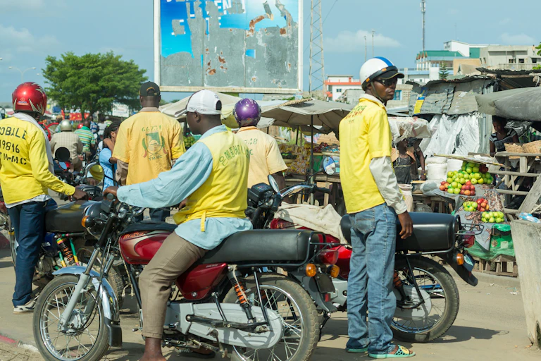 Plusieurs personnes sur des motos dans une ville d'Afrique