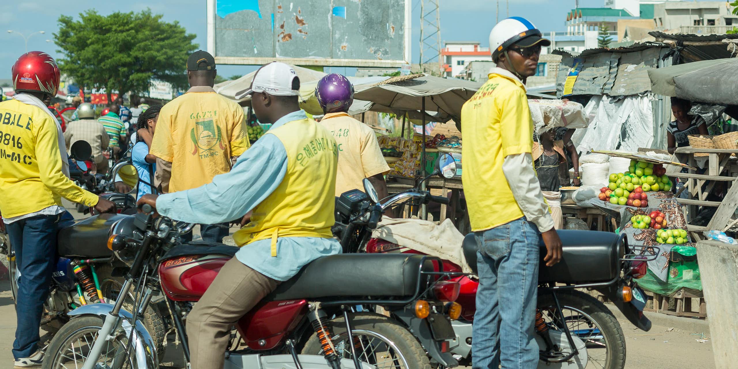 Plusieurs personnes sur des motos dans une ville d'Afrique