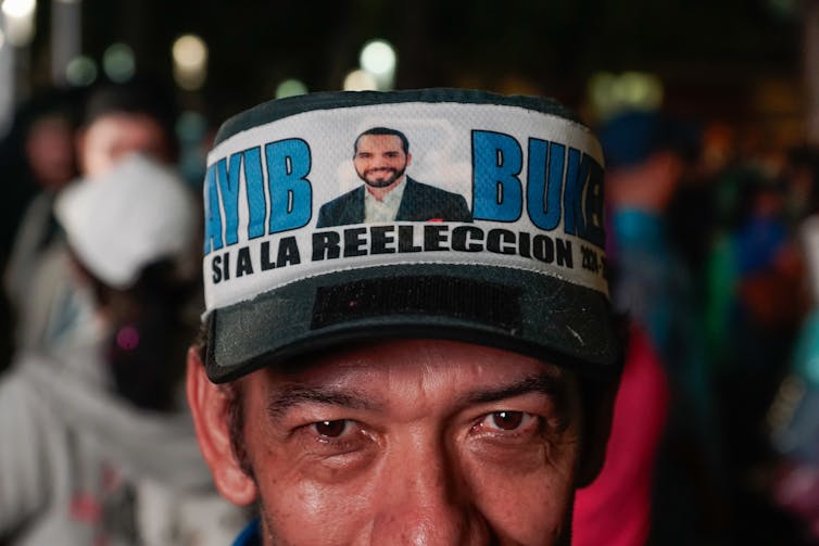 A man wears a hat showing the image of President Nayib Bukele.