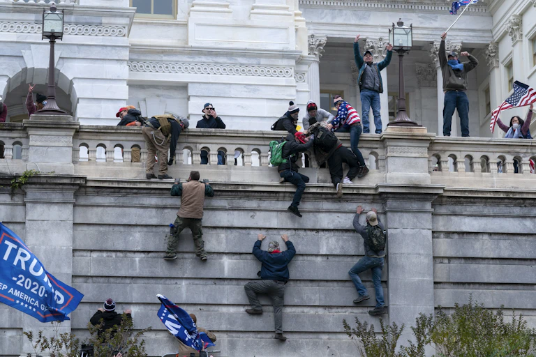 People climbing the wall of a massive building