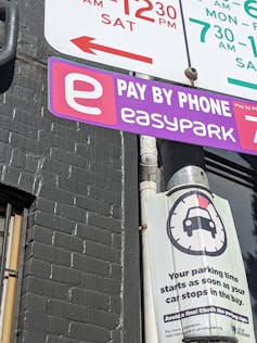 A pink parking sign that states 'Pay by Phone EasyPark'