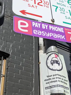A pink parking sign that states 'Pay by Phone EasyPark'