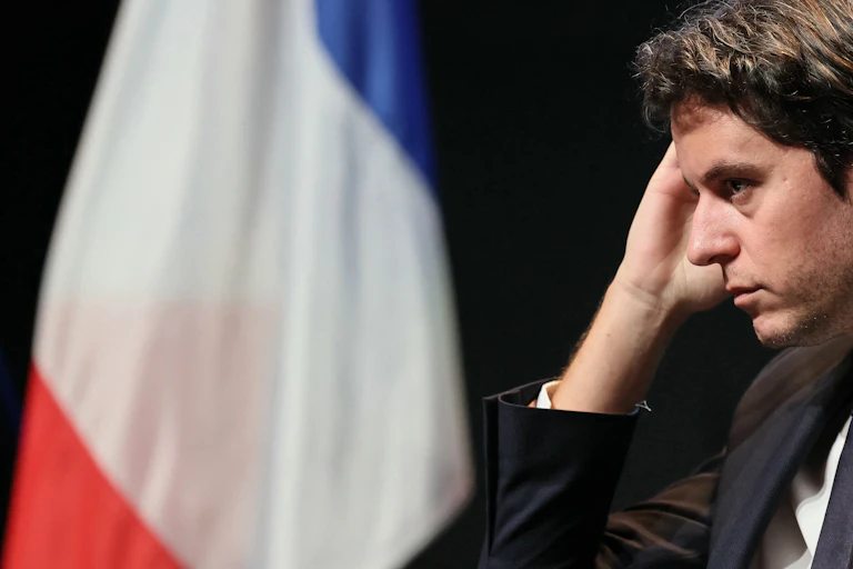 Gabriel Attal devant un drapeau français lors d'un discours