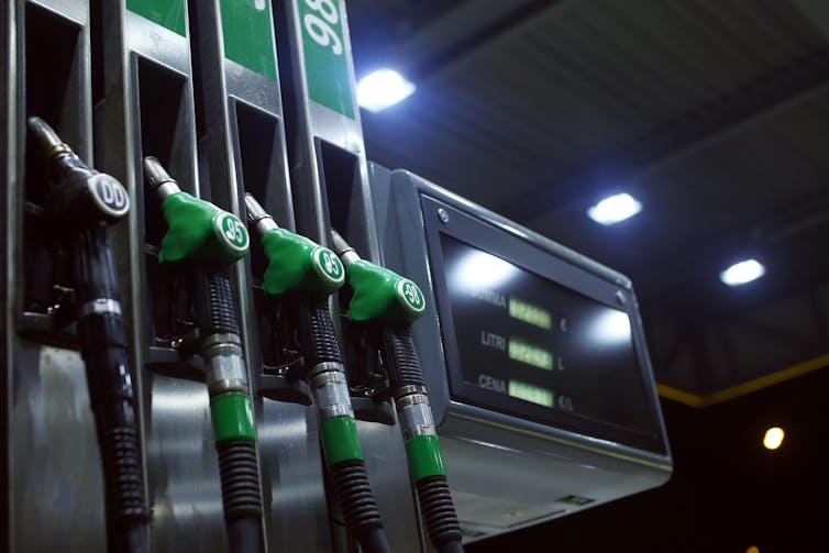 Four diesel pumps in a station forecourt at night.