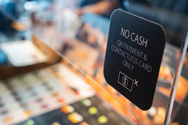 Un cartel advierte a los clientes de que sólo pueden pagar con un código QR o una tarjeta sin contacto, no en efectivo.