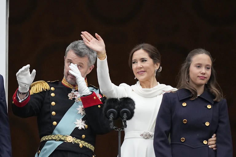 Gray-haired man wearing white gloves dressed in military regalia wipes away a tear.