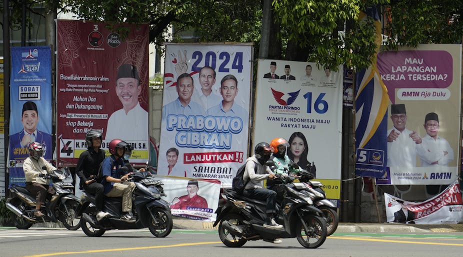 Motorists ride past political banners.