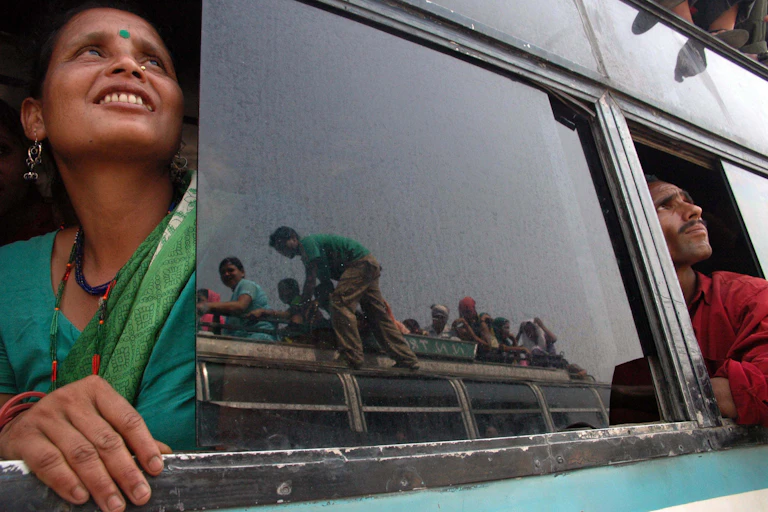 Two people look out of a bus