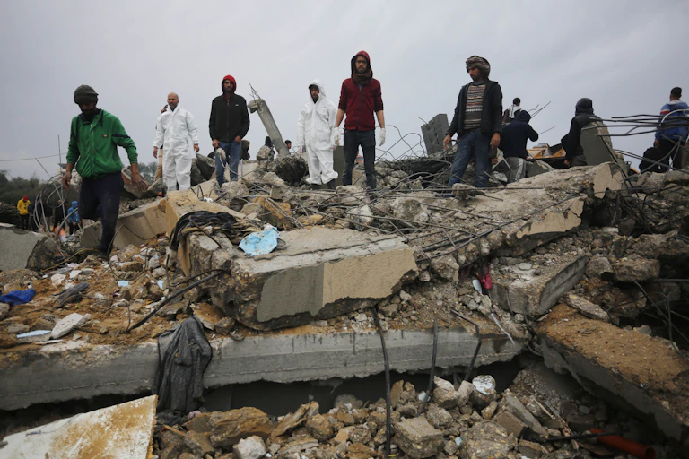 People stand amid concrete rubble from destroyed building