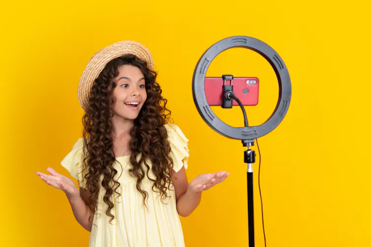Teenager performing in front of her iPhone as she records a blog post