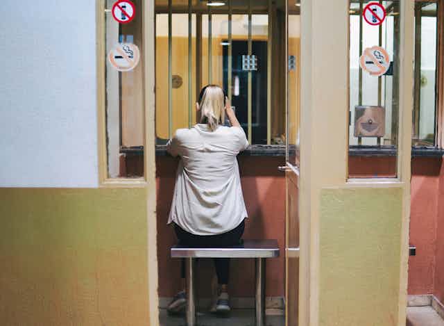 The back of a woman in a prison visitation area