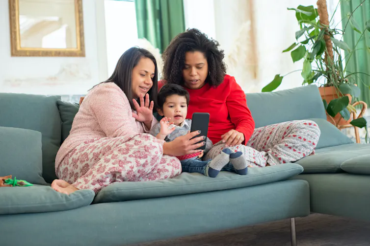 Two mums with a baby on a couch