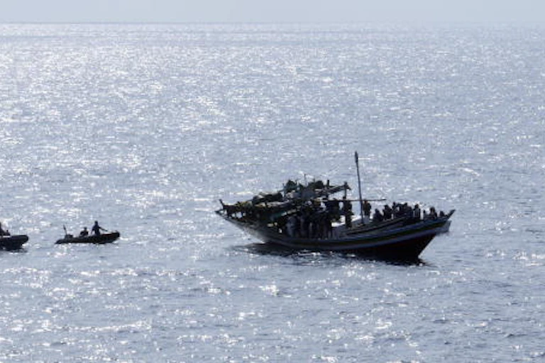 Three small craft around a fishing boat on the water.