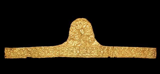 Gold band with ornate detailing against a black backdrop 