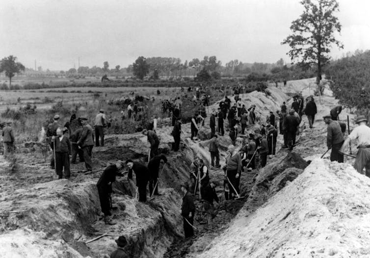 An archival photograph of people digging.