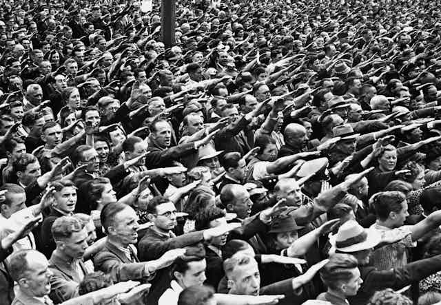An archival photograph of a crowd giving the Nazi salute.