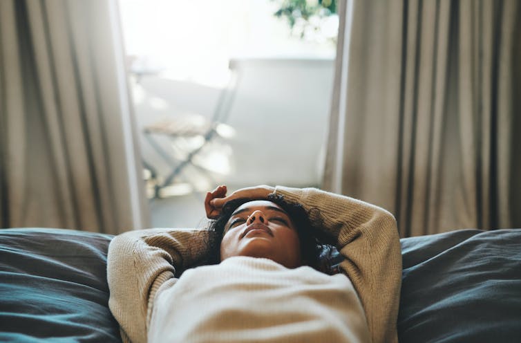 Person lying on back with eyes closed