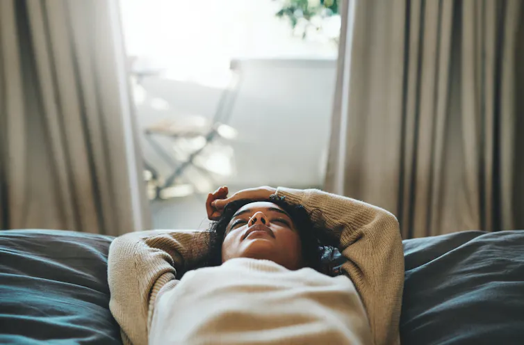 Person lying on back with eyes closed