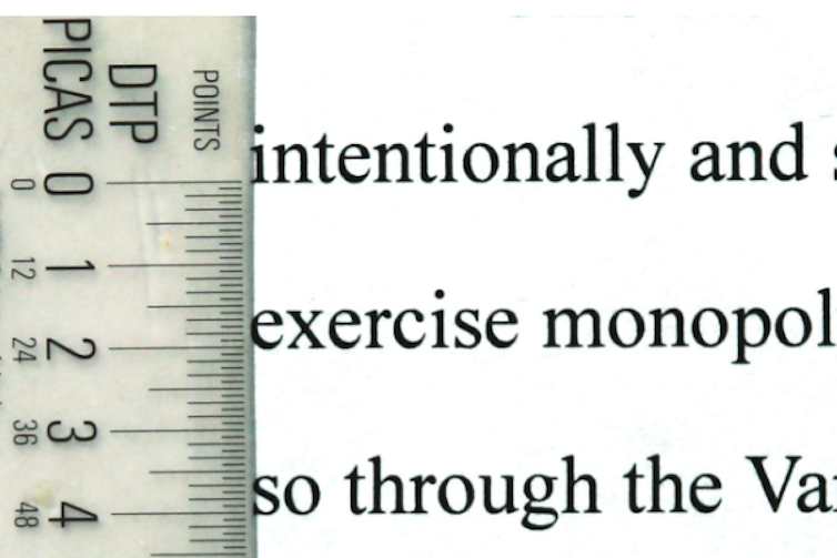 A text excerpt with a measuring pole laid on it.