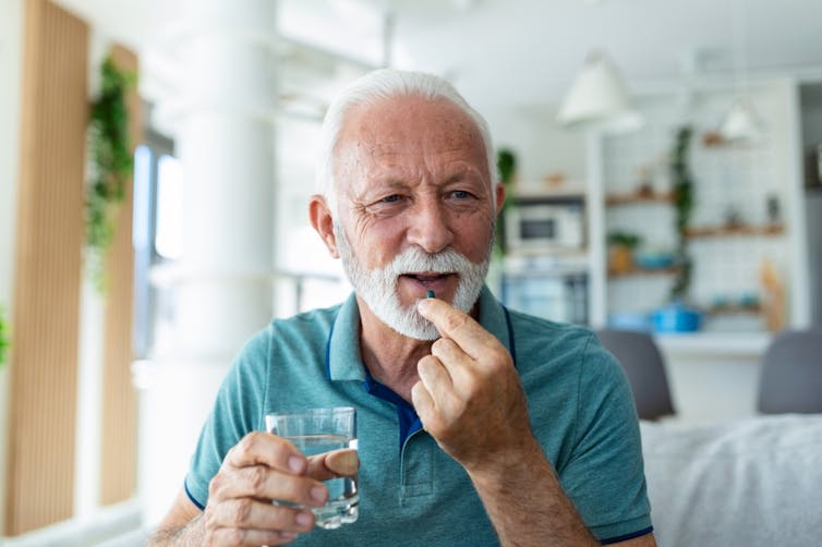 Older man taking a pill