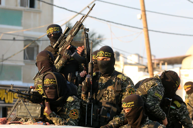 A group of men dressed in military uniform holding automatic weapons.