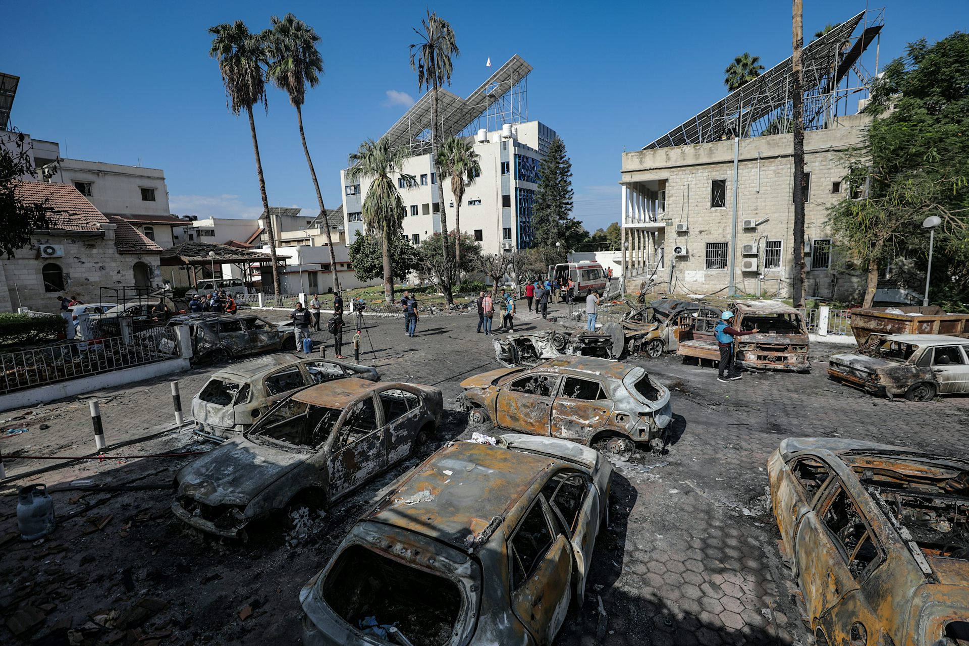 Burnt out cars in a car park on a sunny day.