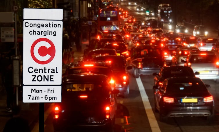 Congestion charge sign and traffic at night