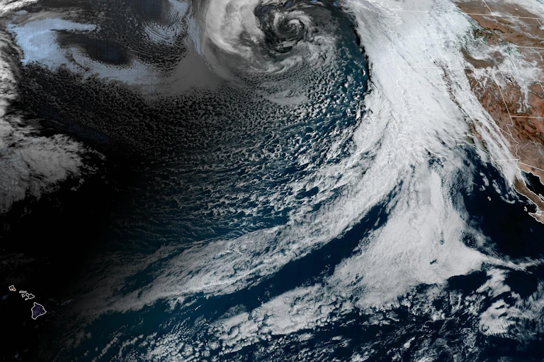 A band of clouds stretches from Hawaii to California and Oregon.