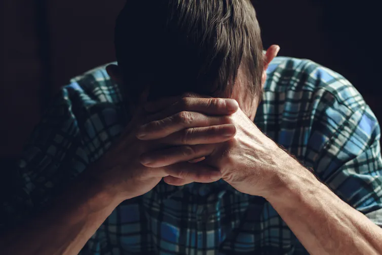 Older man places his hands on his head