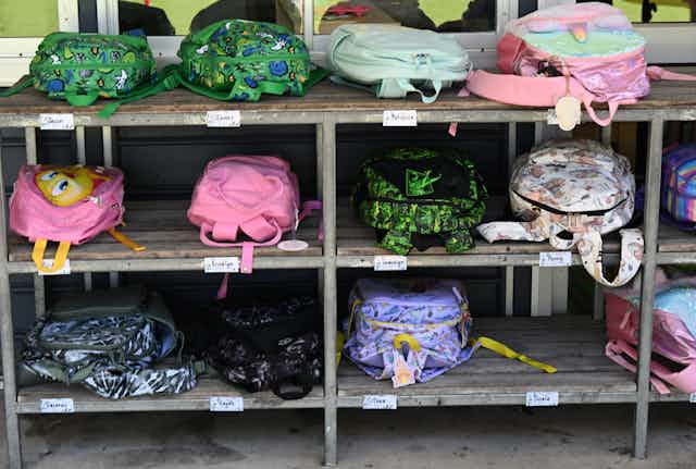 School bags on racks outside a classroom.