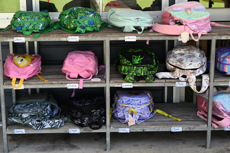 School bags on racks outside a classroom.