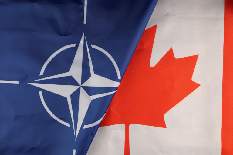 The NATO and Canadian flags seen next to each other.