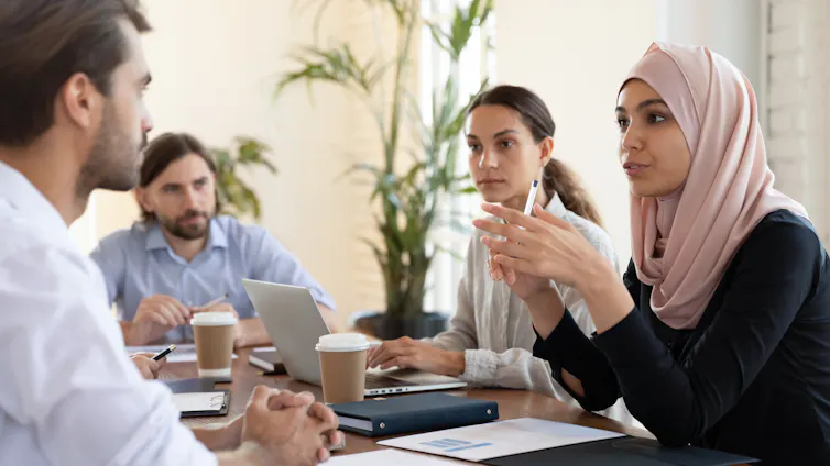 A diverse group of people sitting around a table and having a conversation