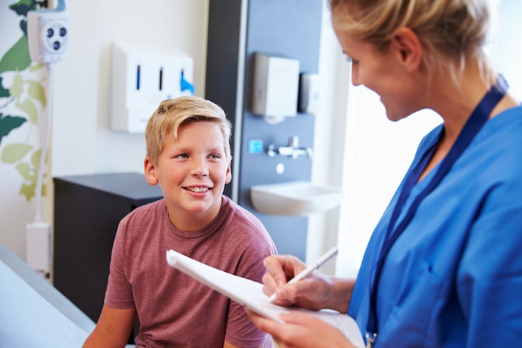 A boy is assessed by a health-care professional.