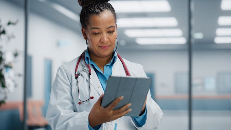 Woman in white box and stethoscope with iPad