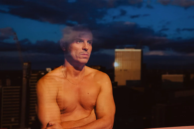 Adam stares out a window.