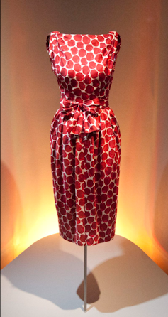 A 1960s style red and white silk dress on a dress form.