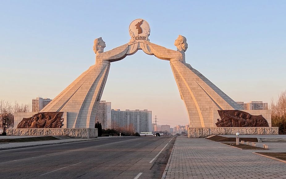 A large marble monument featuring two women in dresses holding aloft an image of a unified Korean peninsula.
