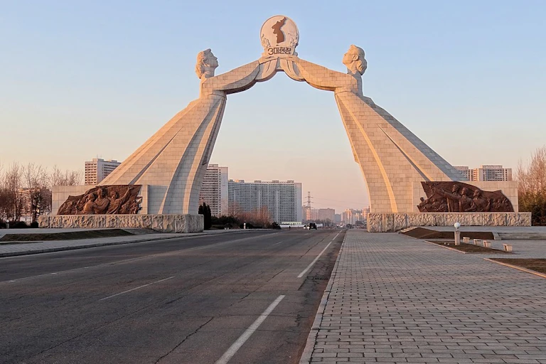 A large marble monument featuring two women in dresses holding aloft an image of a unified Korean peninsula.