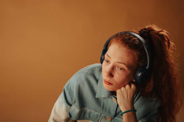 sad redheaded girl with headphones on